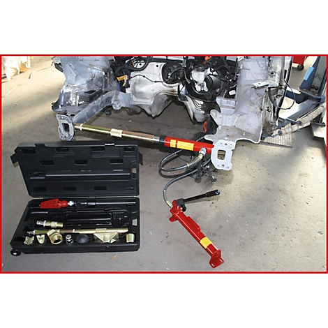 Werkzeug zur Reparatur eines Autoteils. Verschiedene Werkzeuge liegen in einem schwarzen Koffer. An einem Rahmen ist ein Reparaturwerkzeug angebracht.